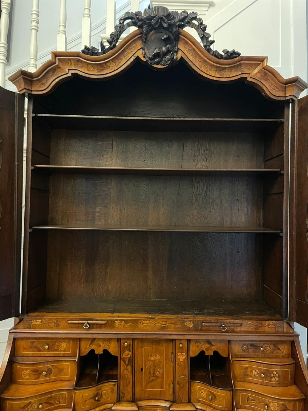 An 18th-century Dutch burr walnut bureau bookcase featuring intricate floral marquetry, a bombe lower drawer section, a fall-front desk slope, and an arched twin-door upper cabinet supported on claw feet. View IV