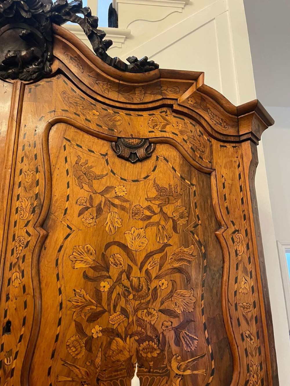 An 18th-century Dutch burr walnut bureau bookcase featuring intricate floral marquetry, a bombe lower drawer section, a fall-front desk slope, and an arched twin-door upper cabinet supported on claw feet. View VII