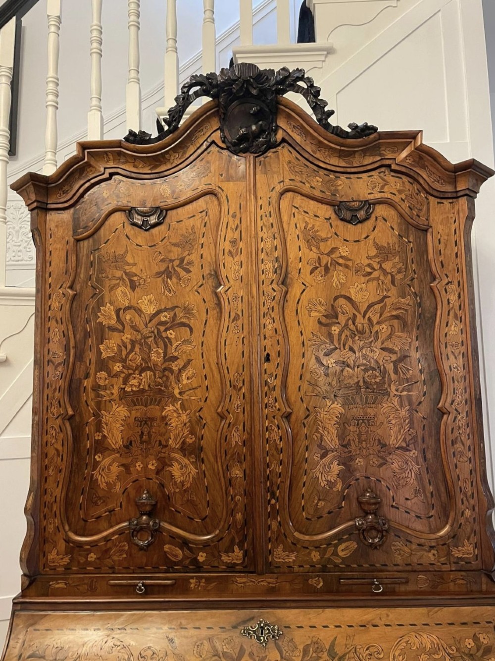 An 18th-century Dutch burr walnut bureau bookcase featuring intricate floral marquetry, a bombe lower drawer section, a fall-front desk slope, and an arched twin-door upper cabinet supported on claw feet. View XIII