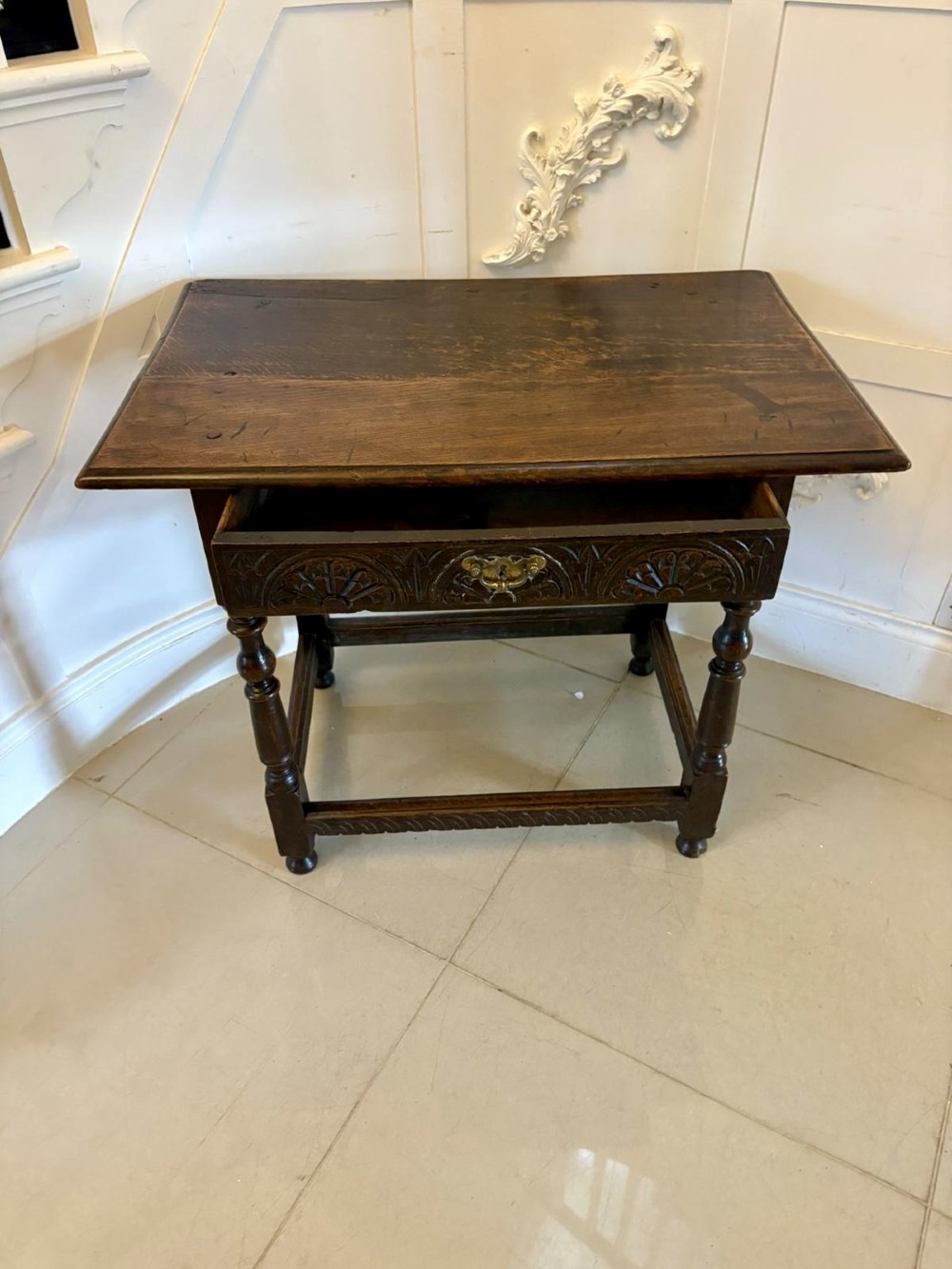 An 18th-century dark oak side table featuring a carved frieze drawer, turned legs, and a rectangular stretcher base. View II