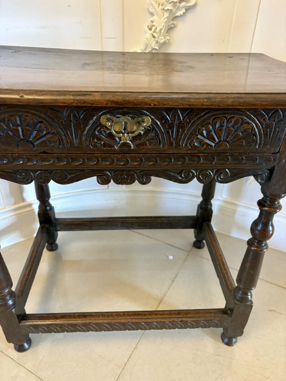 An 18th-century dark oak side table featuring a carved frieze drawer, turned legs, and a rectangular stretcher base. View V