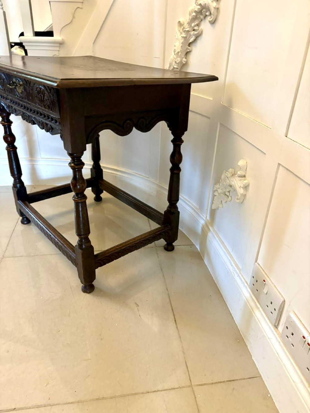 An 18th-century dark oak side table featuring a carved frieze drawer, turned legs, and a rectangular stretcher base. View VI