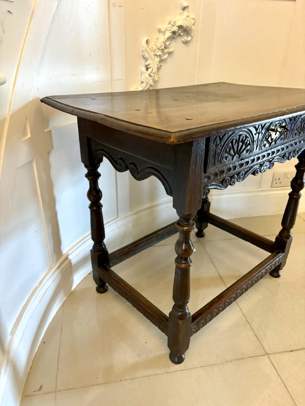 An 18th-century dark oak side table featuring a carved frieze drawer, turned legs, and a rectangular stretcher base. View XI
