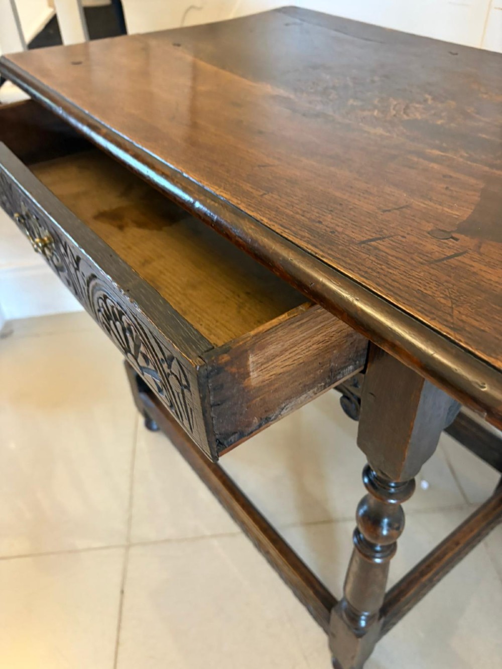 An 18th-century dark oak side table featuring a carved frieze drawer, turned legs, and a rectangular stretcher base. View XIV