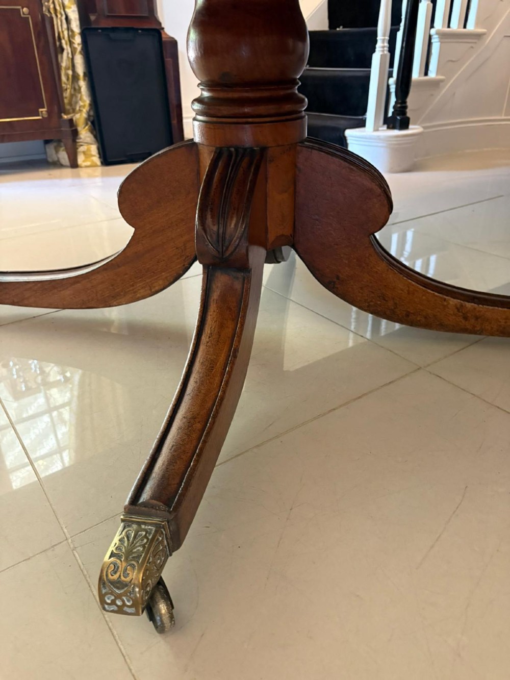A large George III figured mahogany twin-pillar extending dining table with splayed tripod legs ending in brass castors. View IV