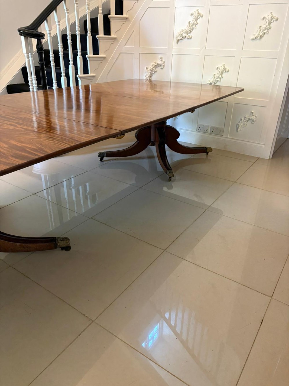 A large George III figured mahogany twin-pillar extending dining table with splayed tripod legs ending in brass castors. View VI