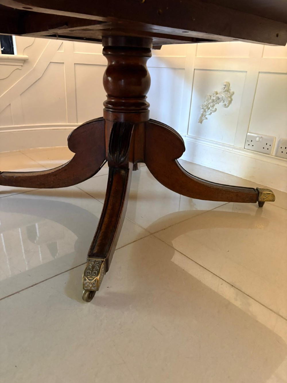 A large George III figured mahogany twin-pillar extending dining table with splayed tripod legs ending in brass castors. View VII