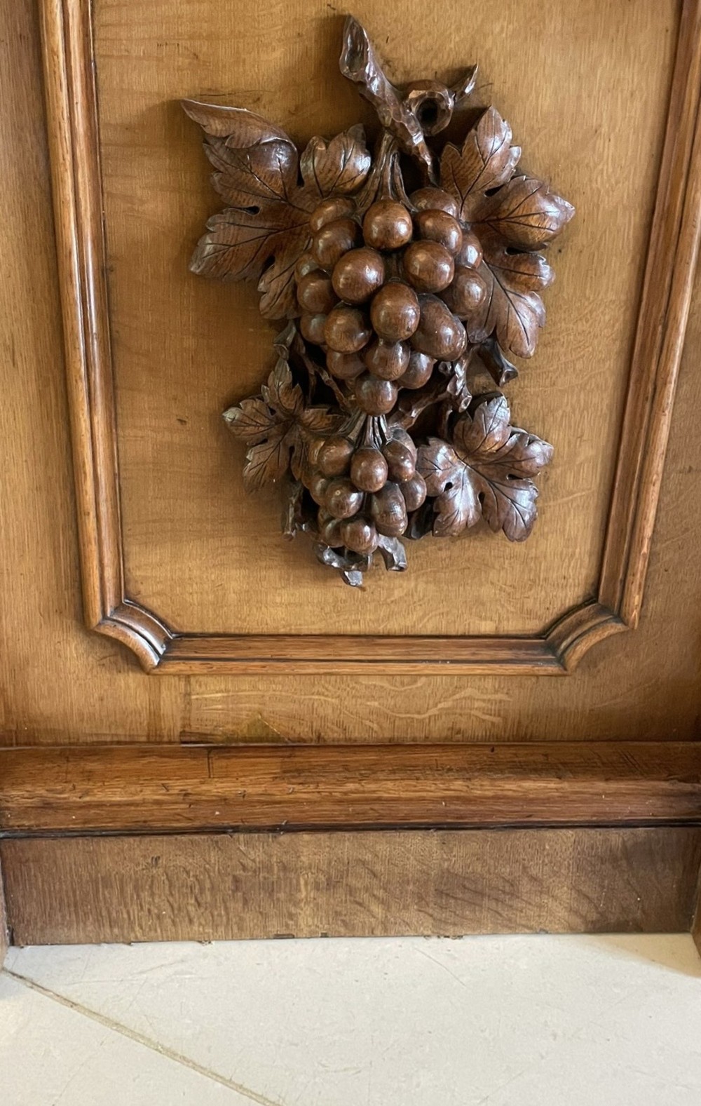A large Victorian carved oak sideboard featuring three upper mirror panels, intricate grape cluster wood carvings, and a pedestal base. View XV