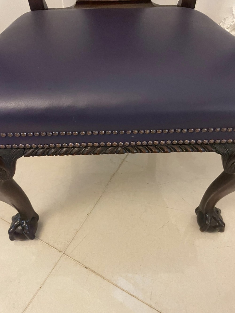 A set of carved mahogany dining chairs featuring pierced back splats, ball and claw feet, and purple leather seats. View IV
