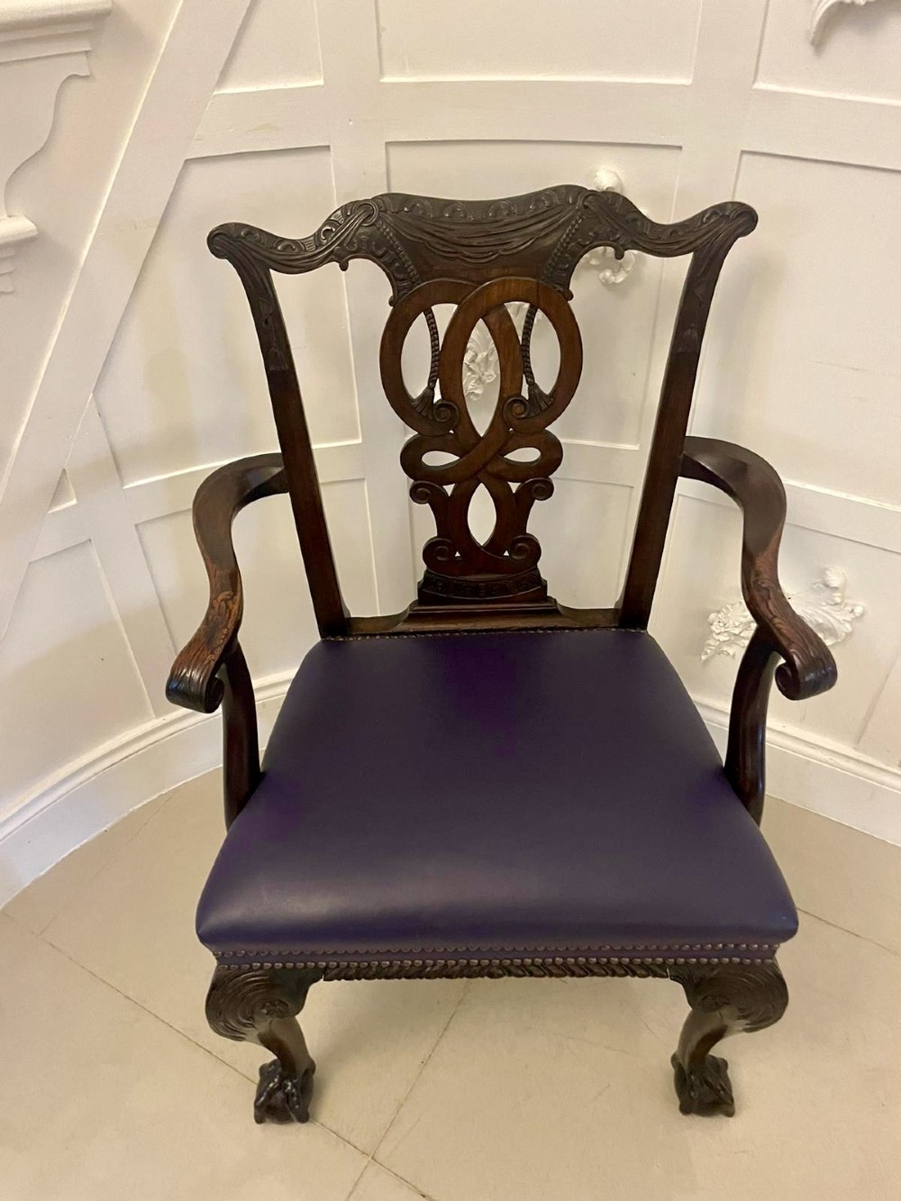 A set of carved mahogany dining chairs featuring pierced back splats, ball and claw feet, and purple leather seats. View V