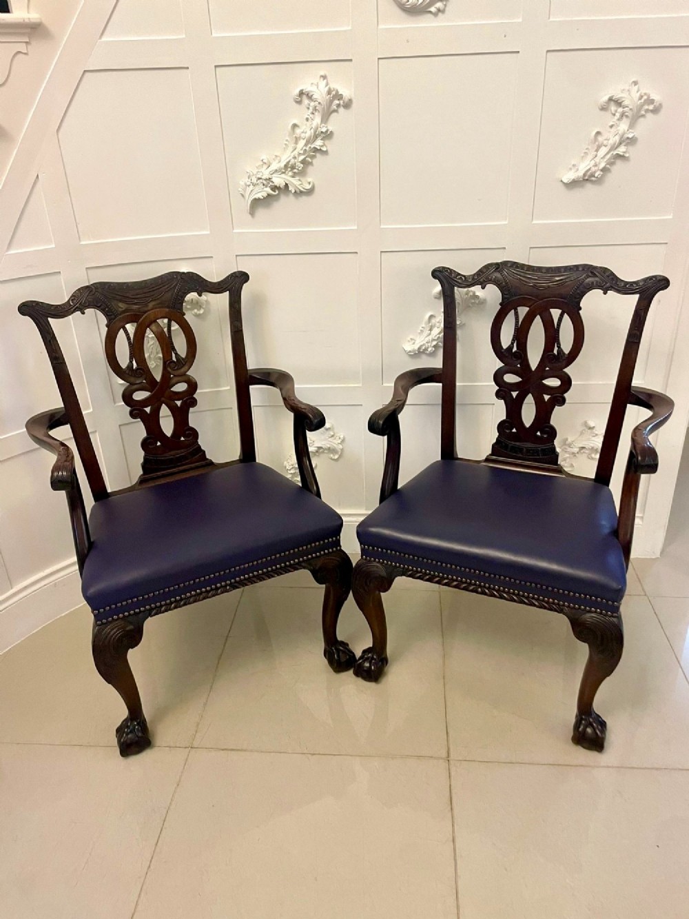 A set of carved mahogany dining chairs featuring pierced back splats, ball and claw feet, and purple leather seats. View VII