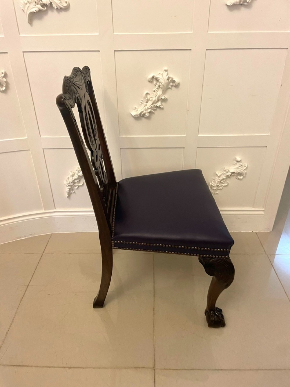 A set of carved mahogany dining chairs featuring pierced back splats, ball and claw feet, and purple leather seats. View VIII