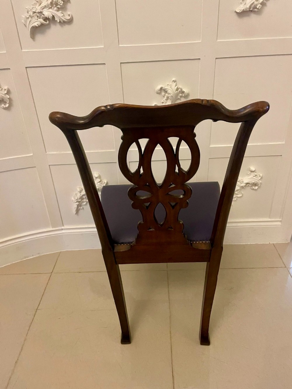 A set of carved mahogany dining chairs featuring pierced back splats, ball and claw feet, and purple leather seats. View IX