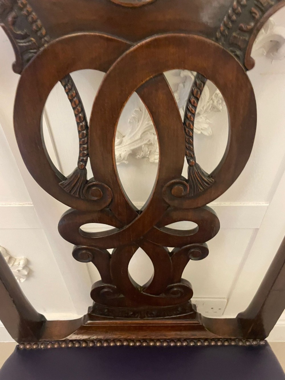 A set of carved mahogany dining chairs featuring pierced back splats, ball and claw feet, and purple leather seats. View XIII