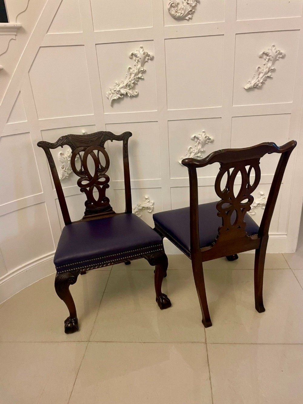 A set of carved mahogany dining chairs featuring pierced back splats, ball and claw feet, and purple leather seats. View XIV