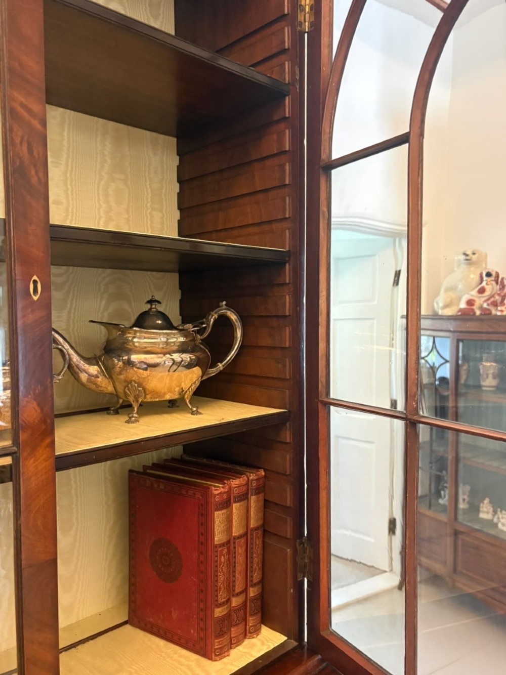 A tall Georgian mahogany secretaire bookcase featuring an upper cabinet with astragal glazed doors and a lower chest of drawers with brass handles. View VII