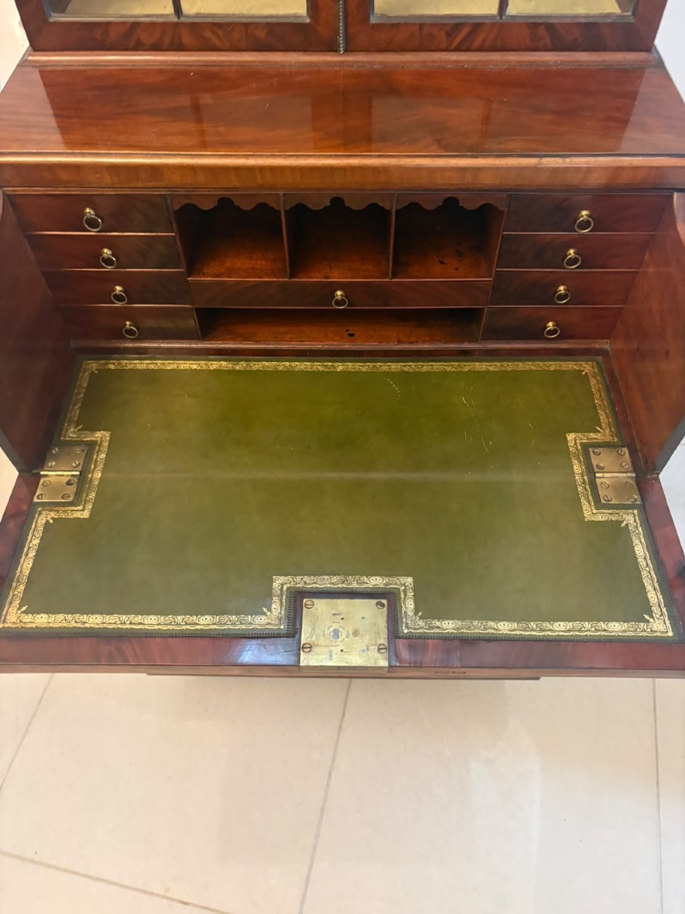 A tall Georgian mahogany secretaire bookcase featuring an upper cabinet with astragal glazed doors and a lower chest of drawers with brass handles. View IX