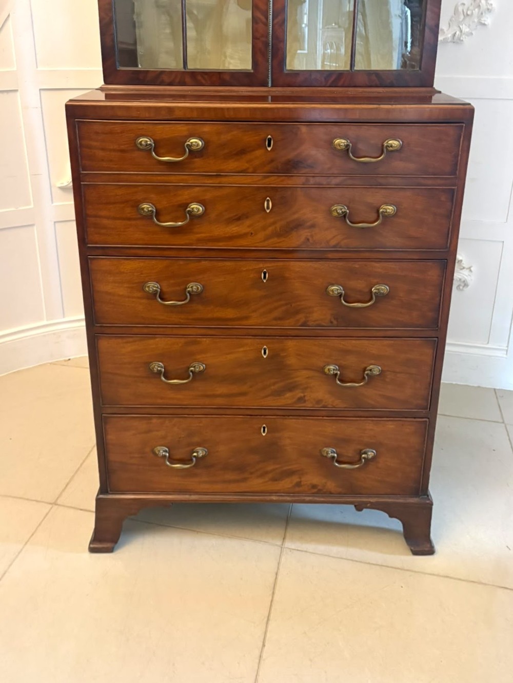 A tall Georgian mahogany secretaire bookcase featuring an upper cabinet with astragal glazed doors and a lower chest of drawers with brass handles. View XIV