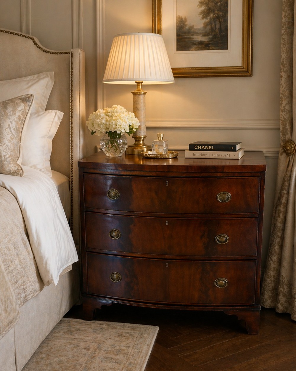A Georgian mahogany bow-front chest of three drawers featuring oval brass drop handles and raised on bracket feet. View IV