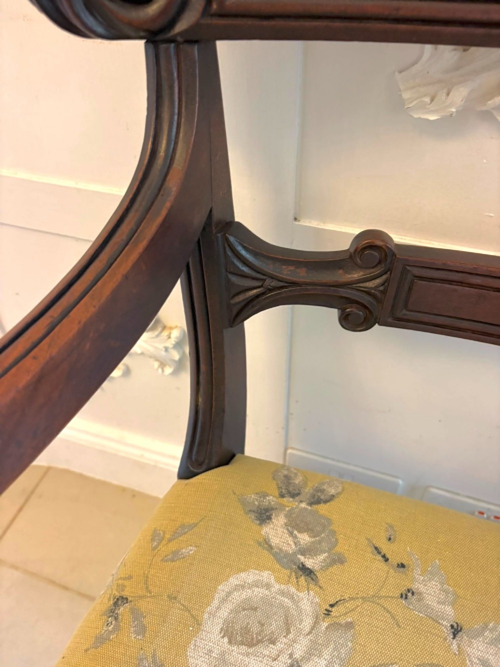 A set of eight Regency mahogany dining chairs featuring carved scroll crest rails, turned front legs, and floral upholstered seats, including two carvers. View XIV