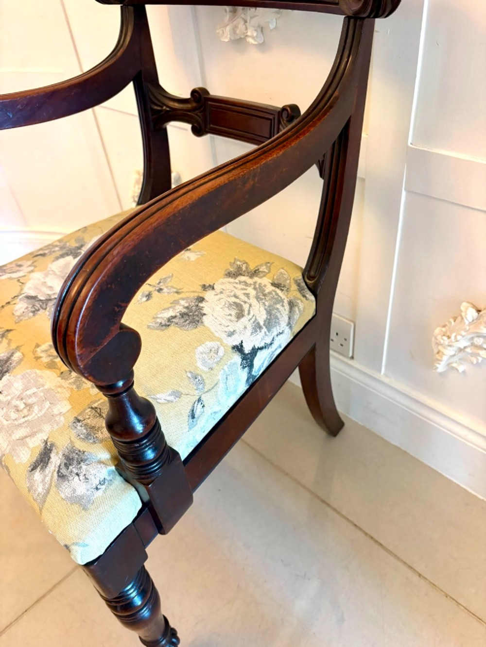 A set of eight Regency mahogany dining chairs featuring carved scroll crest rails, turned front legs, and floral upholstered seats, including two carvers. View XV