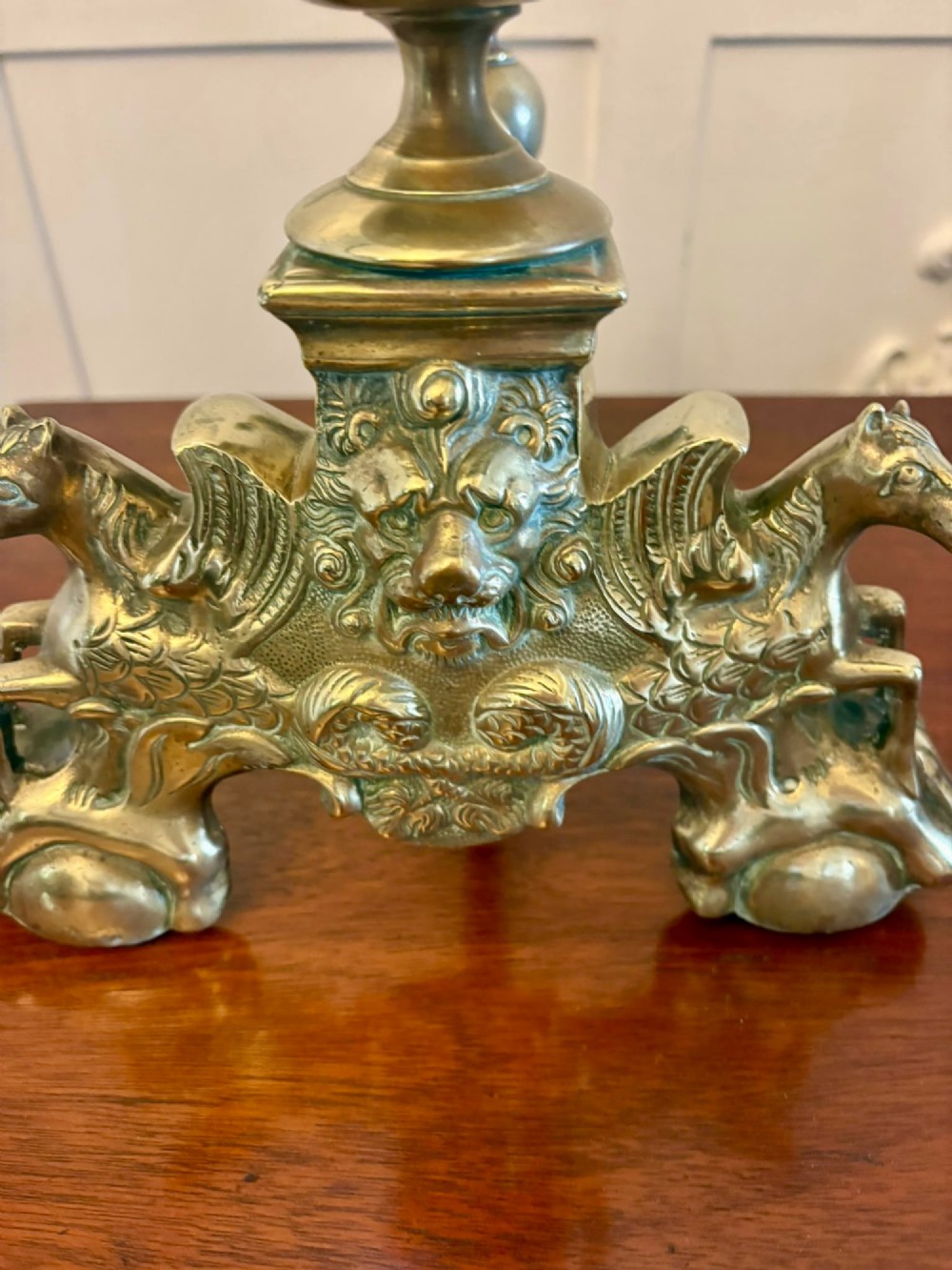 A pair of ornate Victorian cast brass fire dogs featuring spiral-fluted finials, gadrooned central urns, and mythological horse motifs on the base. View VIII