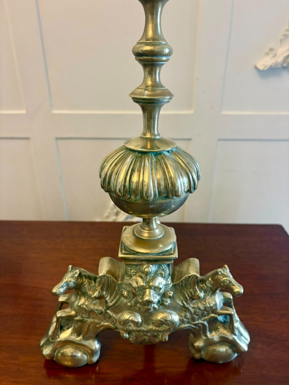 A pair of ornate Victorian cast brass fire dogs featuring spiral-fluted finials, gadrooned central urns, and mythological horse motifs on the base. View X