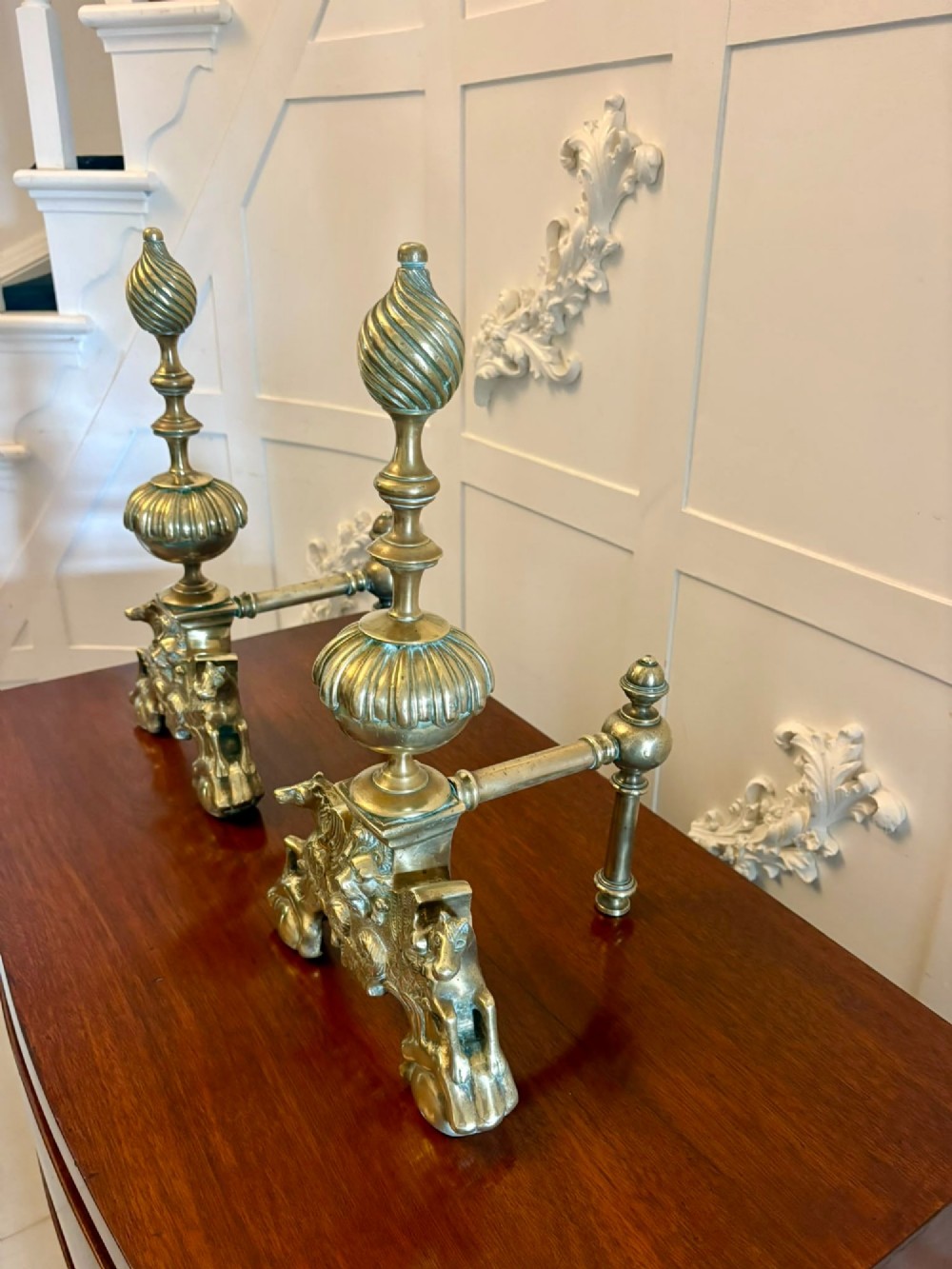 A pair of ornate Victorian cast brass fire dogs featuring spiral-fluted finials, gadrooned central urns, and mythological horse motifs on the base. View XIII
