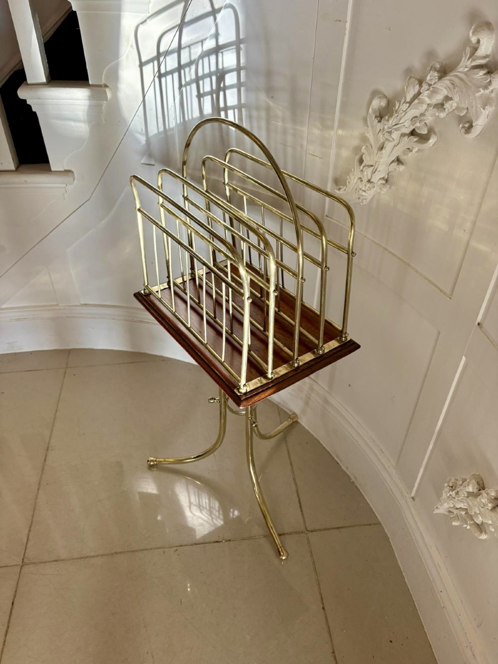 An antique Victorian brass magazine rack with divided wire compartments set upon a polished rectangular oak base and a curved brass tripod stand. View IV