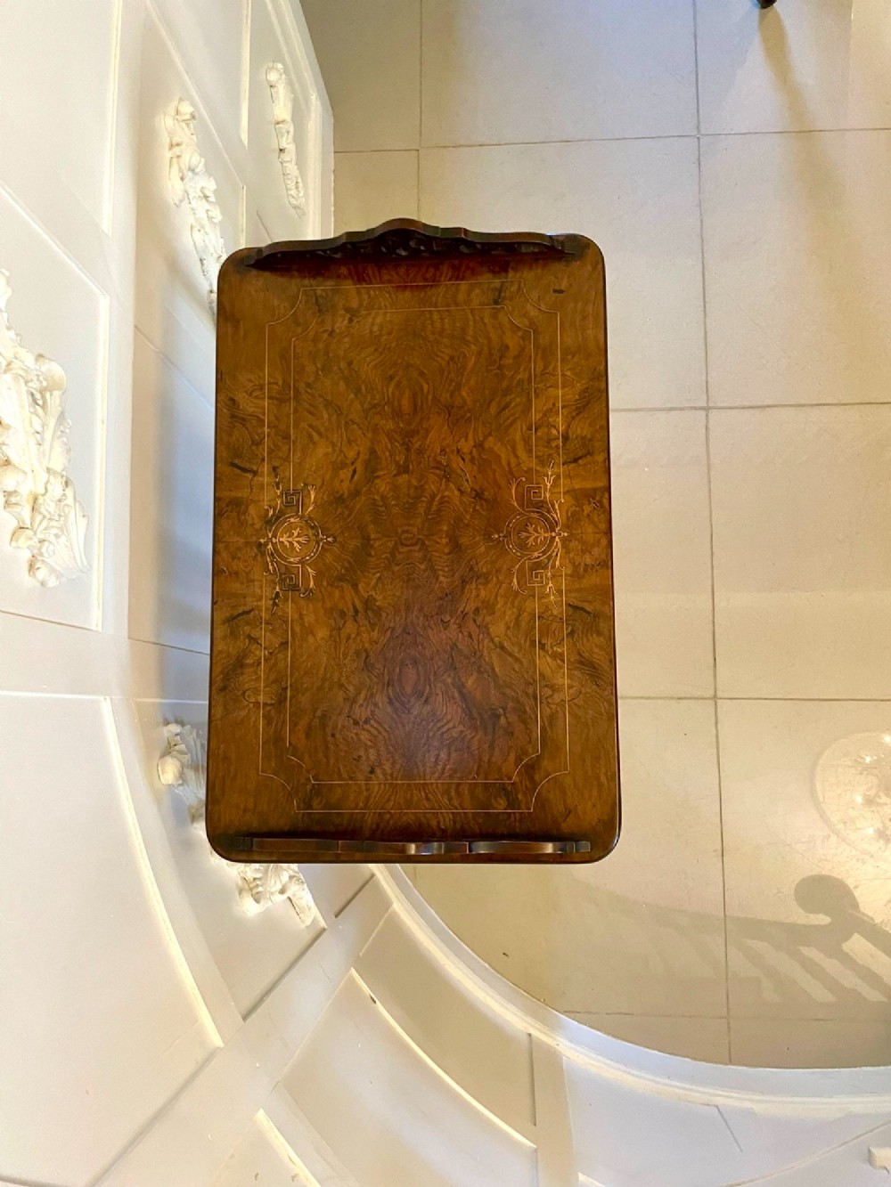 An antique Victorian burr walnut music cabinet featuring two open upper shelves supported by turned columns and a lower glass-fronted cupboard with gold lettered divisions on castors. View III