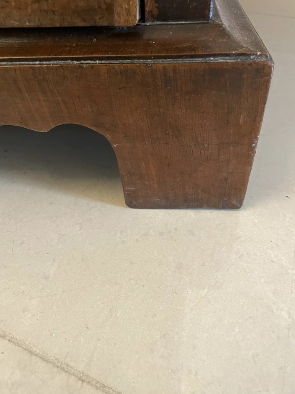 An early 18th-century George I walnut chest of drawers featuring burr walnut veneers, brass drop handles, keyhole escutcheons, and bracket feet. View VI