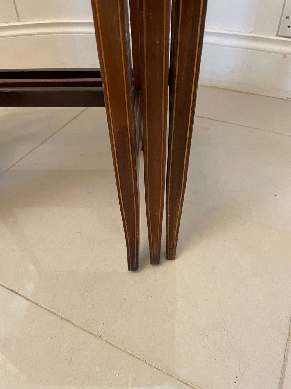 A set of three graduated mahogany nesting tables with central oval satinwood inlays and slender square legs. View IV