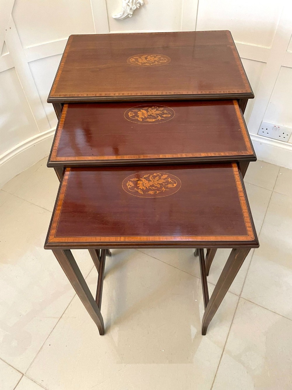 A set of three graduated mahogany nesting tables with central oval satinwood inlays and slender square legs. View XIII