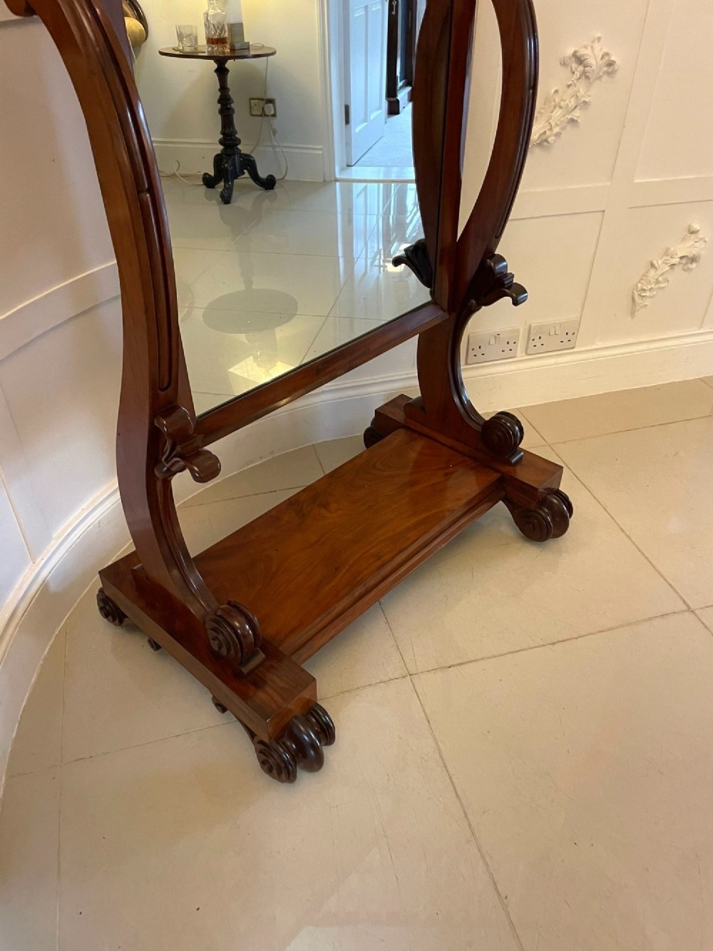 A Victorian mahogany cheval mirror featuring a rectangular swinging frame mounted between curved upright supports on a solid plinth base. View XI