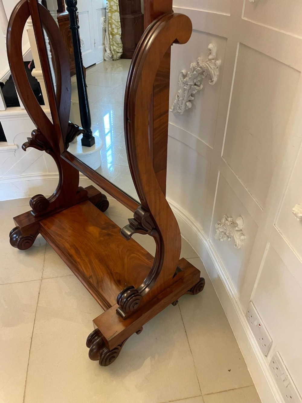 A Victorian mahogany cheval mirror featuring a rectangular swinging frame mounted between curved upright supports on a solid plinth base. View XII