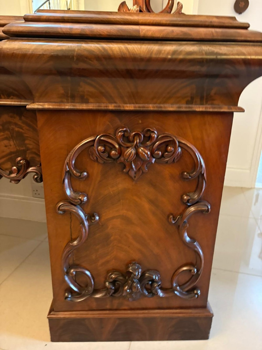 An antique Victorian carved mahogany sideboard featuring twin pedestal bases with carved scroll mouldings and a large arched mirror-backed top frame. View VIII