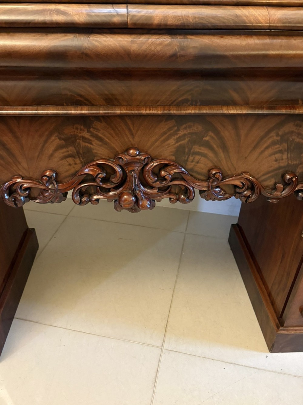 An antique Victorian carved mahogany sideboard featuring twin pedestal bases with carved scroll mouldings and a large arched mirror-backed top frame. View IX