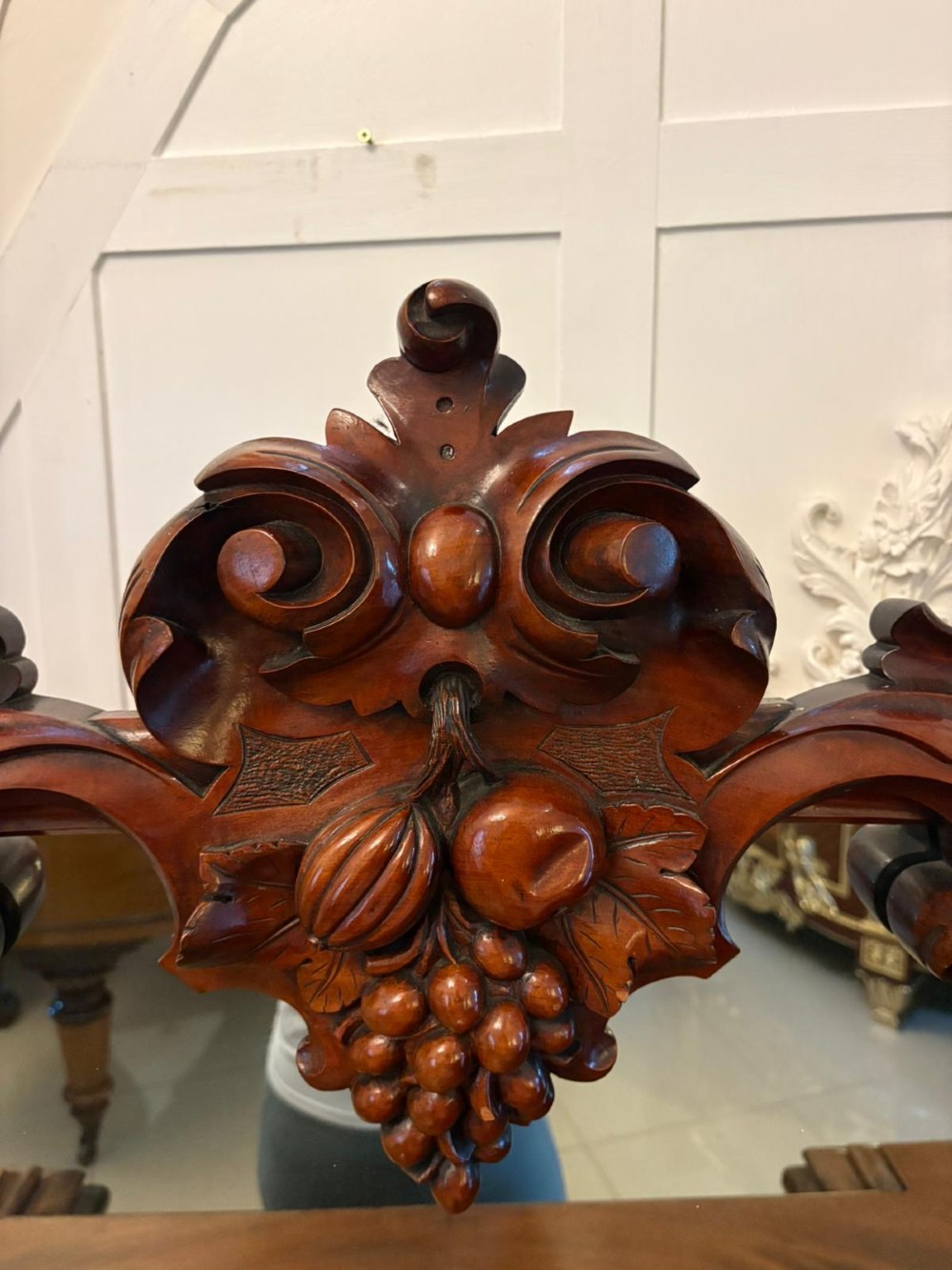 An antique Victorian carved mahogany sideboard featuring twin pedestal bases with carved scroll mouldings and a large arched mirror-backed top frame. View XI