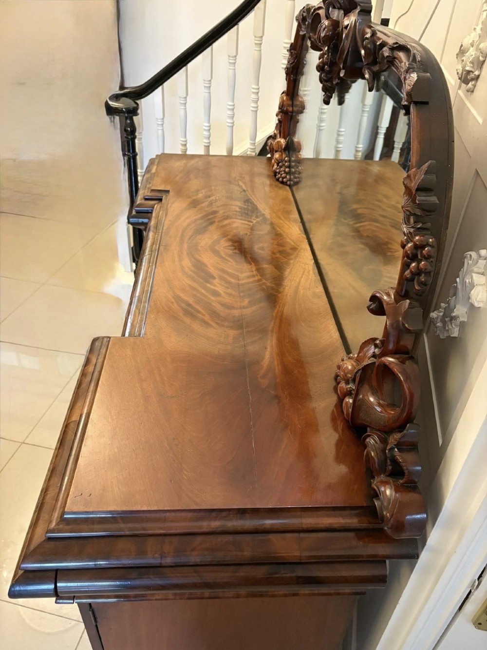 An antique Victorian carved mahogany sideboard featuring twin pedestal bases with carved scroll mouldings and a large arched mirror-backed top frame. View XIII