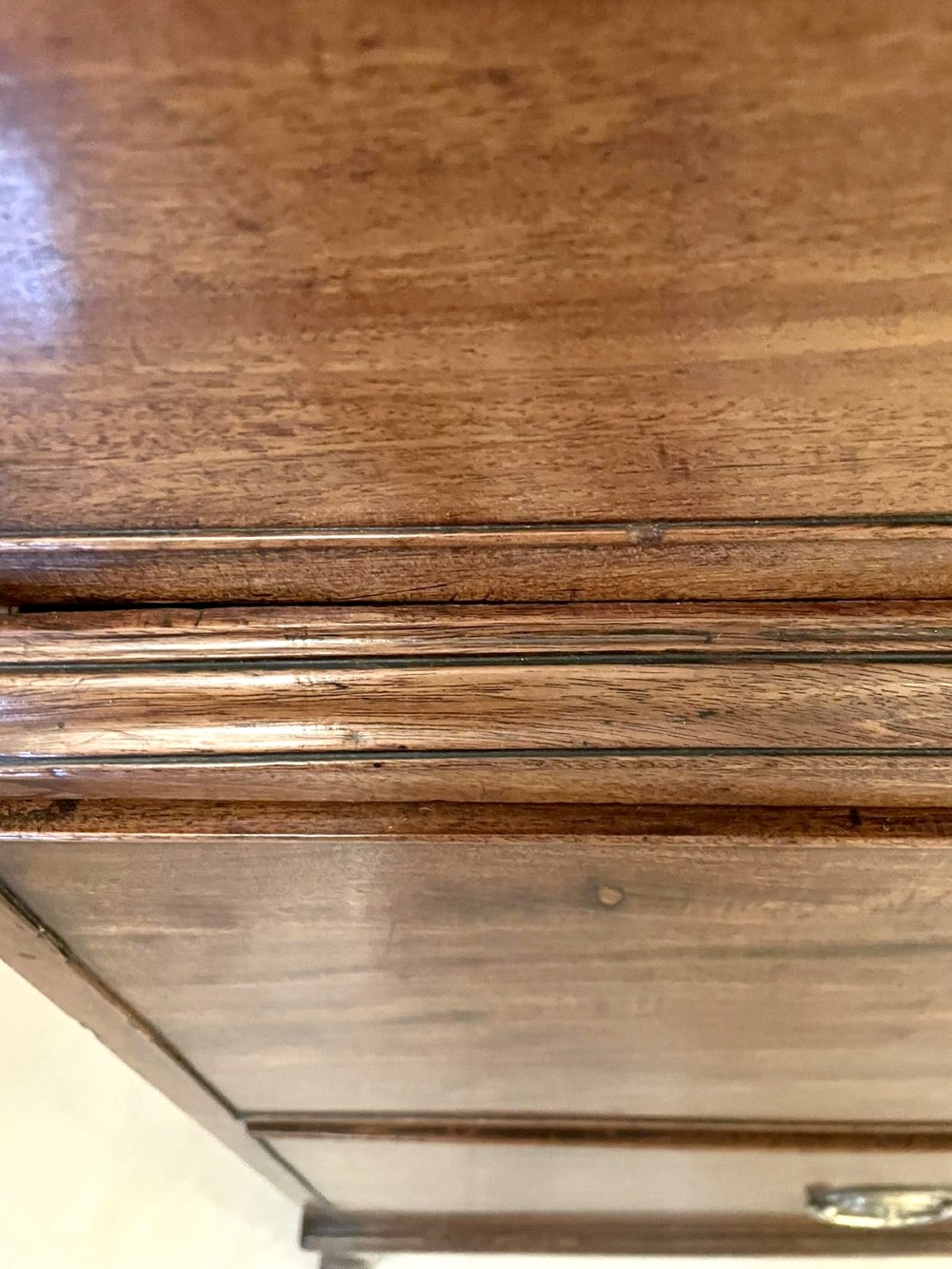 A tall George III figured mahogany chest on chest featuring two short drawers above five long drawers, fitted with oval brass drop handles and supported on bracket feet. View III