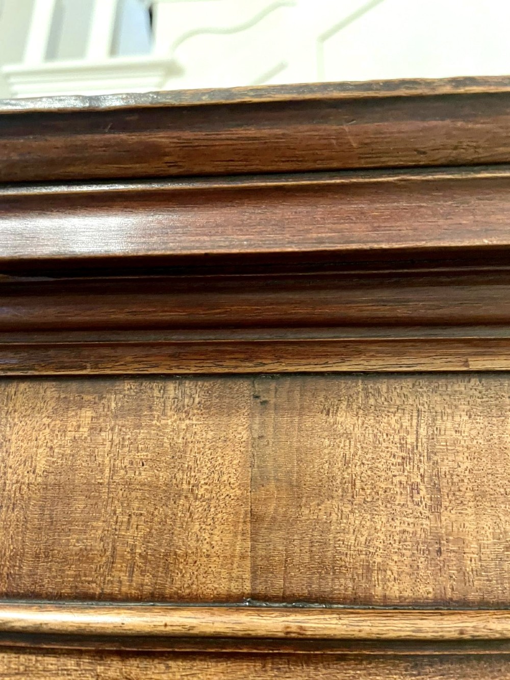 A tall George III figured mahogany chest on chest featuring two short drawers above five long drawers, fitted with oval brass drop handles and supported on bracket feet. View IV