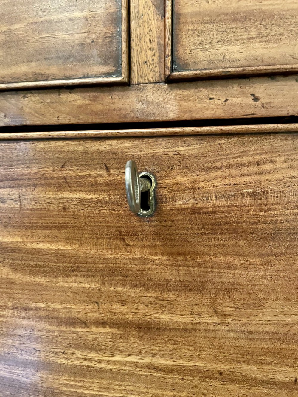 A tall George III figured mahogany chest on chest featuring two short drawers above five long drawers, fitted with oval brass drop handles and supported on bracket feet. View V