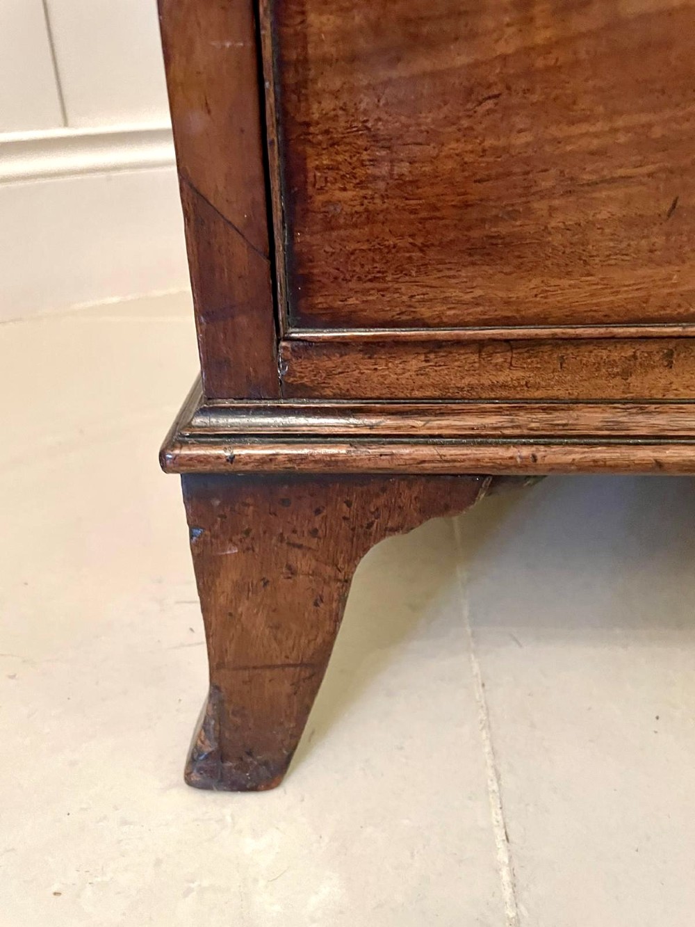 A tall George III figured mahogany chest on chest featuring two short drawers above five long drawers, fitted with oval brass drop handles and supported on bracket feet. View IX