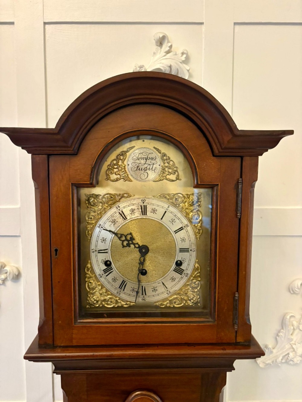 An Edwardian mahogany longcase clock with satinwood urn inlay on the door and a brass dial with Tempus Fugit inscription. View VIII