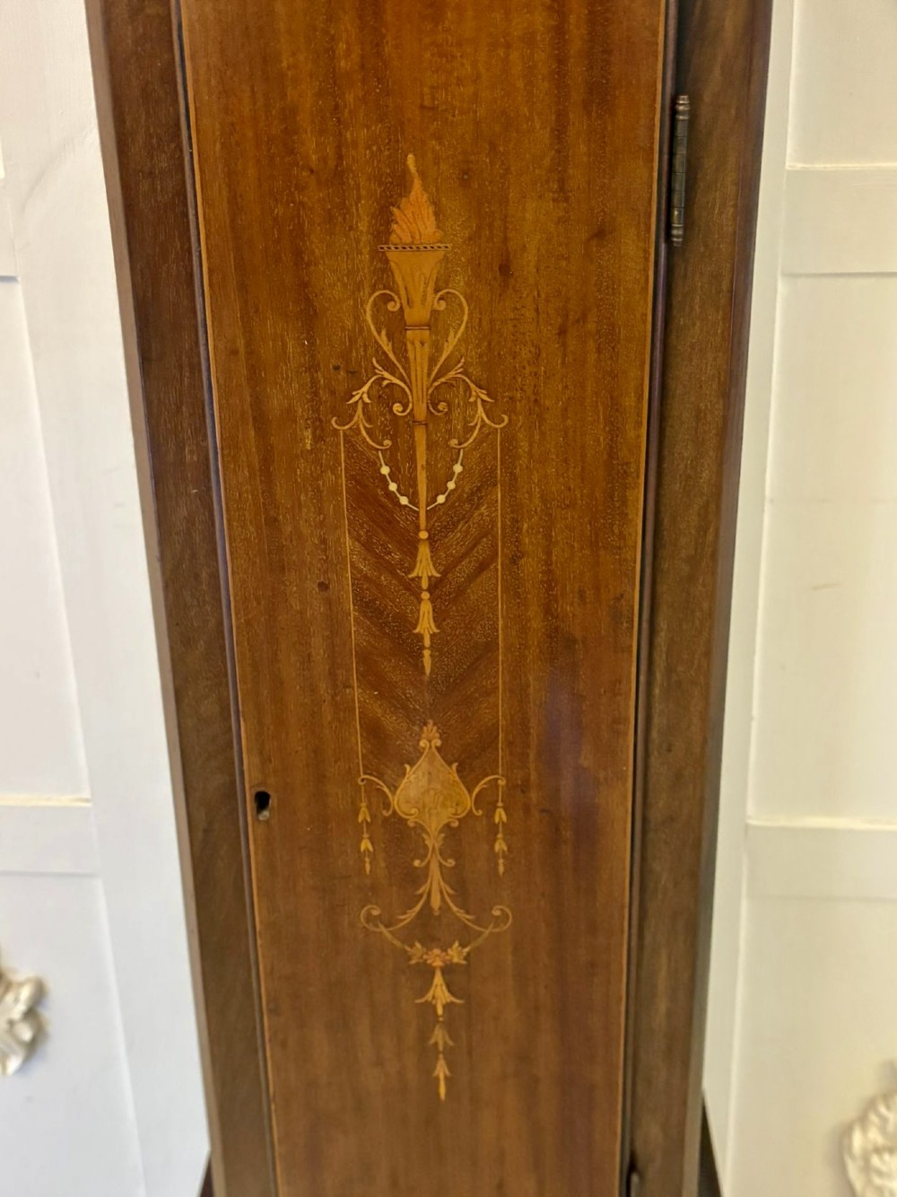 An Edwardian mahogany longcase clock with satinwood urn inlay on the door and a brass dial with Tempus Fugit inscription. View IX
