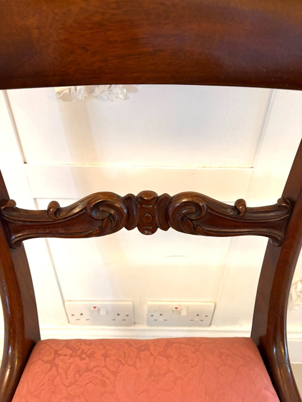 Set of six antique William IV mahogany dining chairs with curved crest rails, scroll carved crossbars, turned front legs, and pink damask upholstered drop-in seats. View III