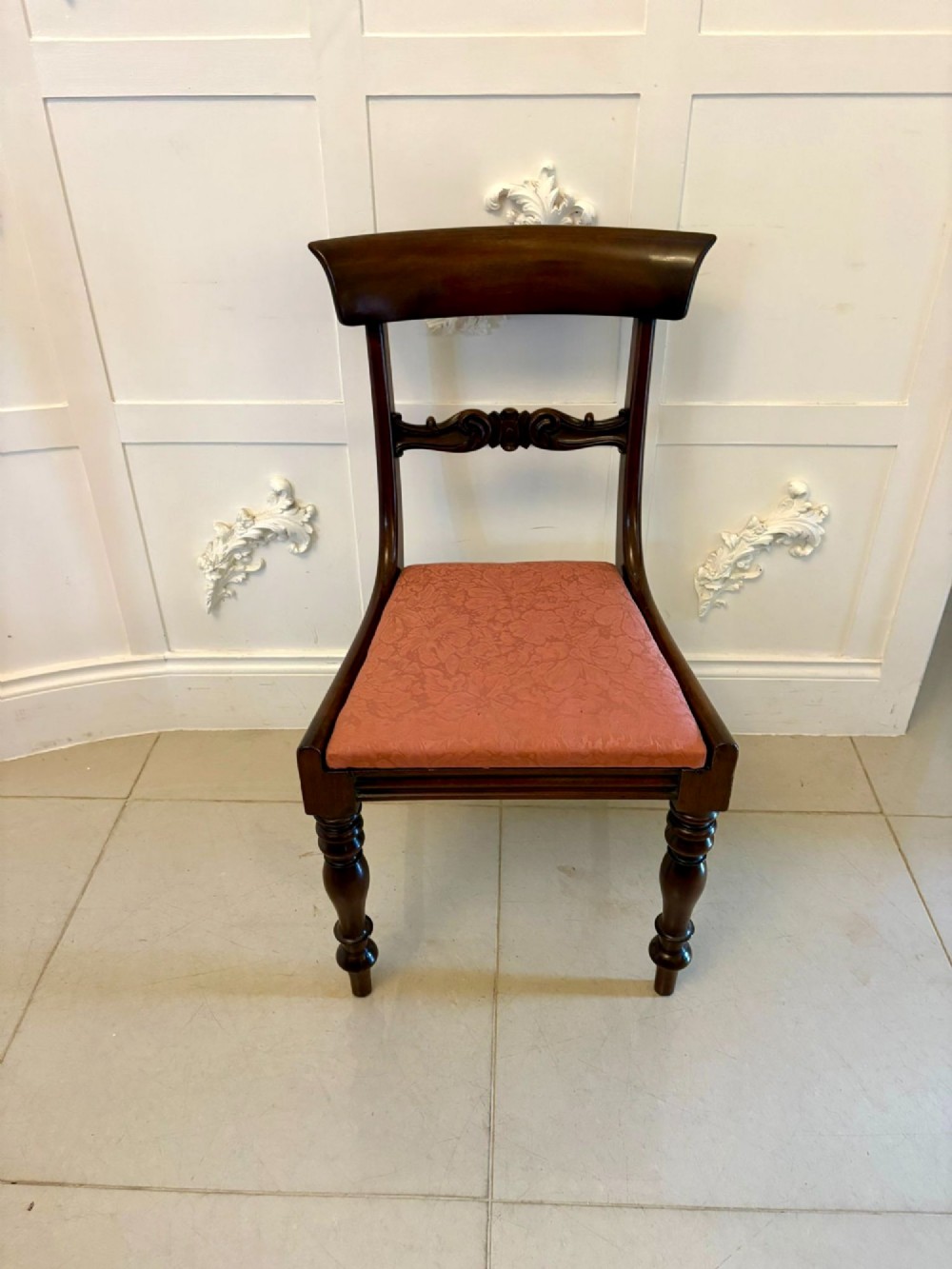 Set of six antique William IV mahogany dining chairs with curved crest rails, scroll carved crossbars, turned front legs, and pink damask upholstered drop-in seats. View IV