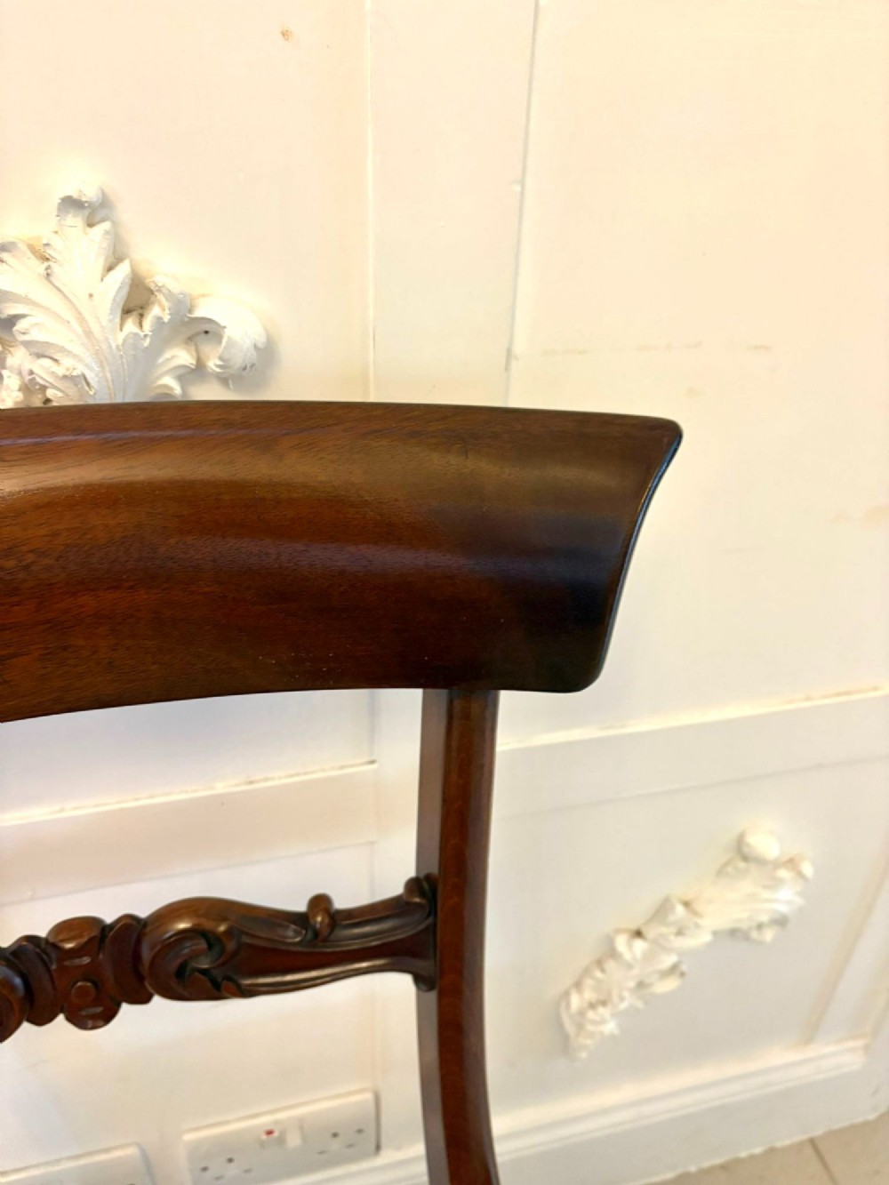Set of six antique William IV mahogany dining chairs with curved crest rails, scroll carved crossbars, turned front legs, and pink damask upholstered drop-in seats. View VII