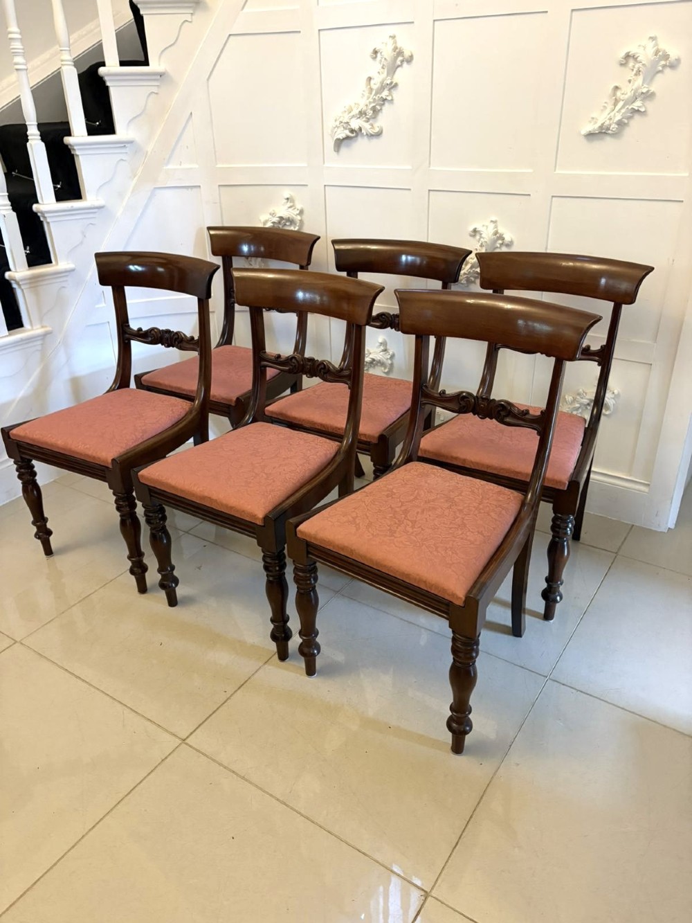 Set of six antique William IV mahogany dining chairs with curved crest rails, scroll carved crossbars, turned front legs, and pink damask upholstered drop-in seats. View VIII