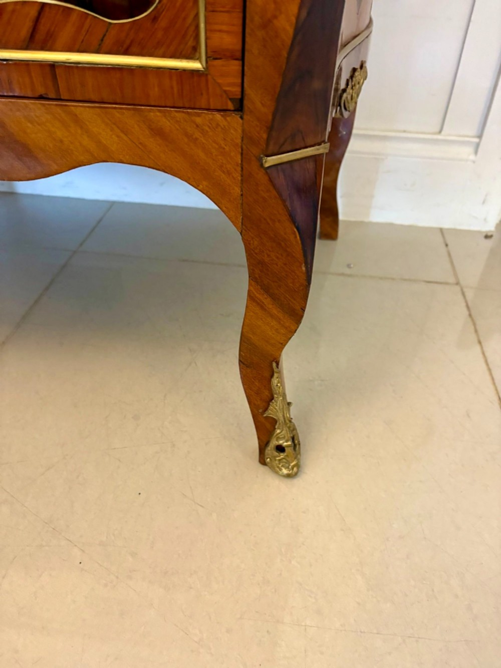 An antique French style commode chest featuring a dark grey veined marble top, decorative walnut veneers, cast brass mounts, and cabriole legs. View III